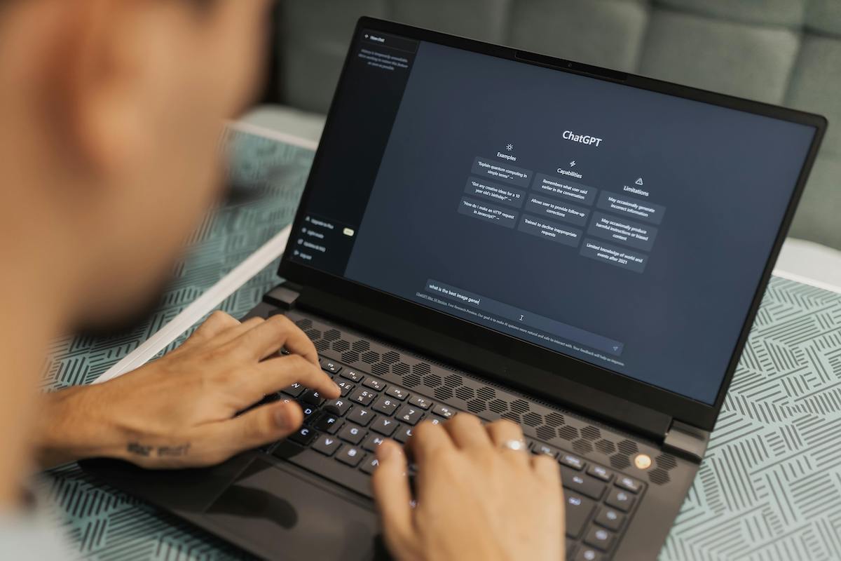A person using a laptop displaying the ChatGPT interface with various options and a dark background. This image illustrates how AI-powered chat platforms like ChatGPT could be perceived as alternatives to traditional couples therapy.